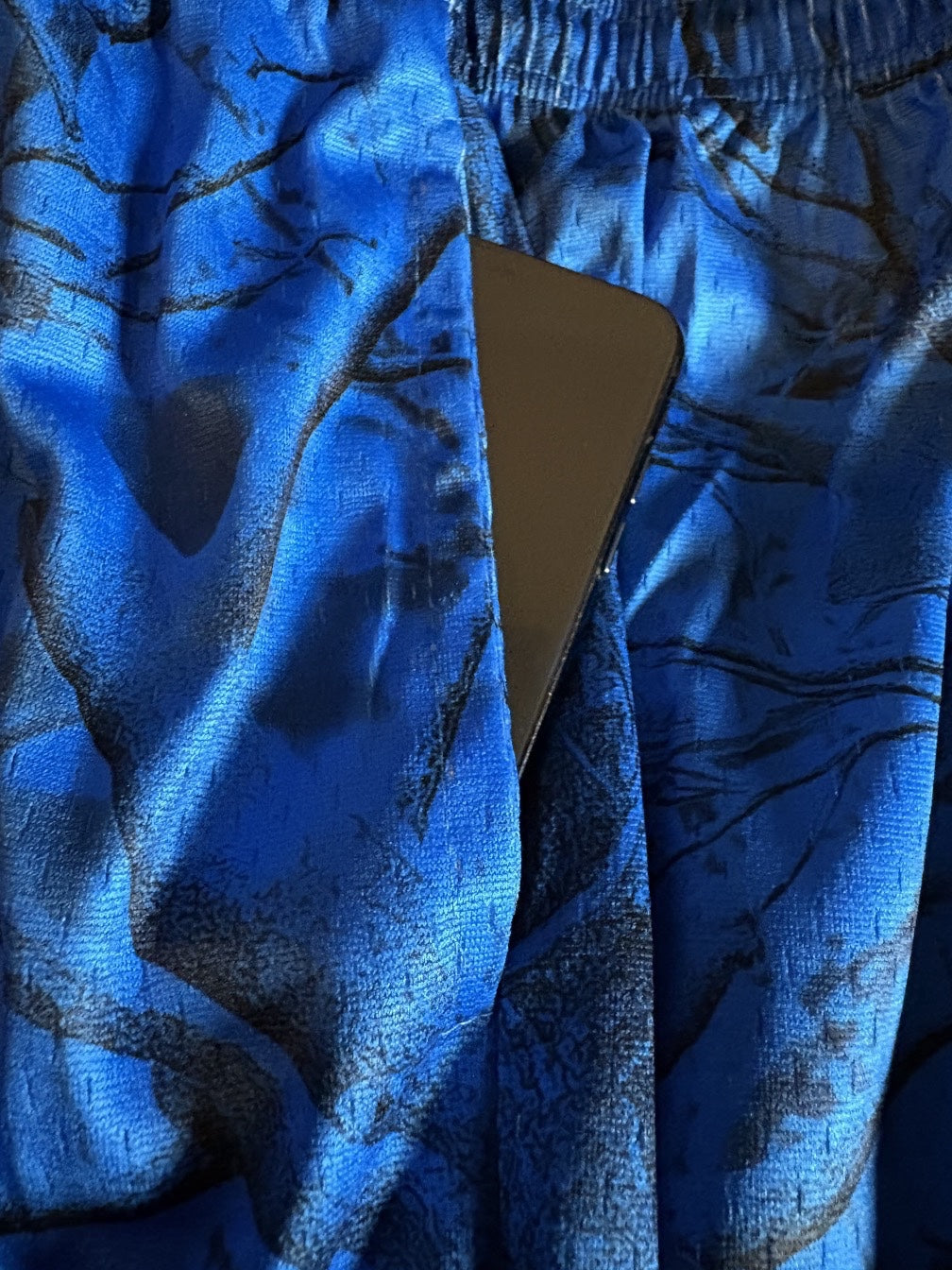 Leaf electric blue mesh performance shorts featuring a dark hunting camo pattern and a side pocket detail.